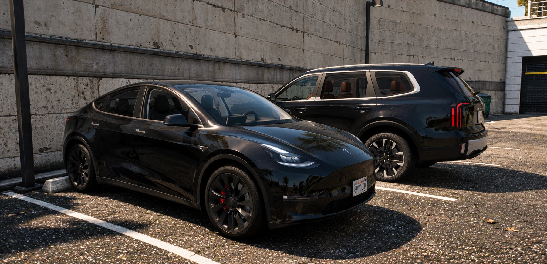 A black Tesla and Kia Telluride parked together outside a concrete building.